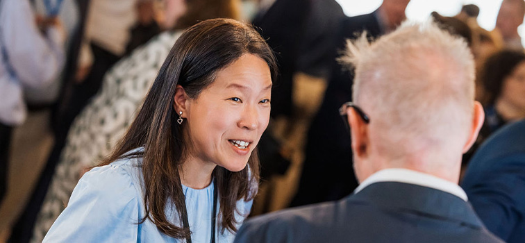 Attendee of the  Sandbox Programme Event at Central Bank of Ireland smiling and talking to a man