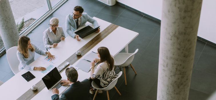 Five people having a meeting around a table