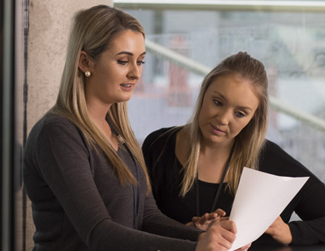 Two women reading a document