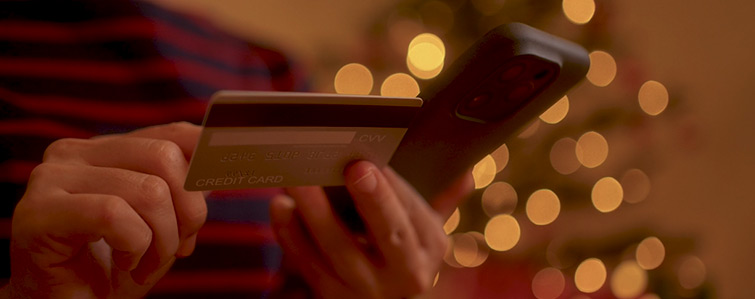 A person holding a bank card and a phone