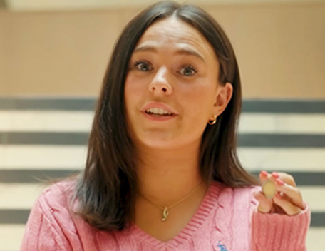 Girl with pink top holding new €2 commemorative coin